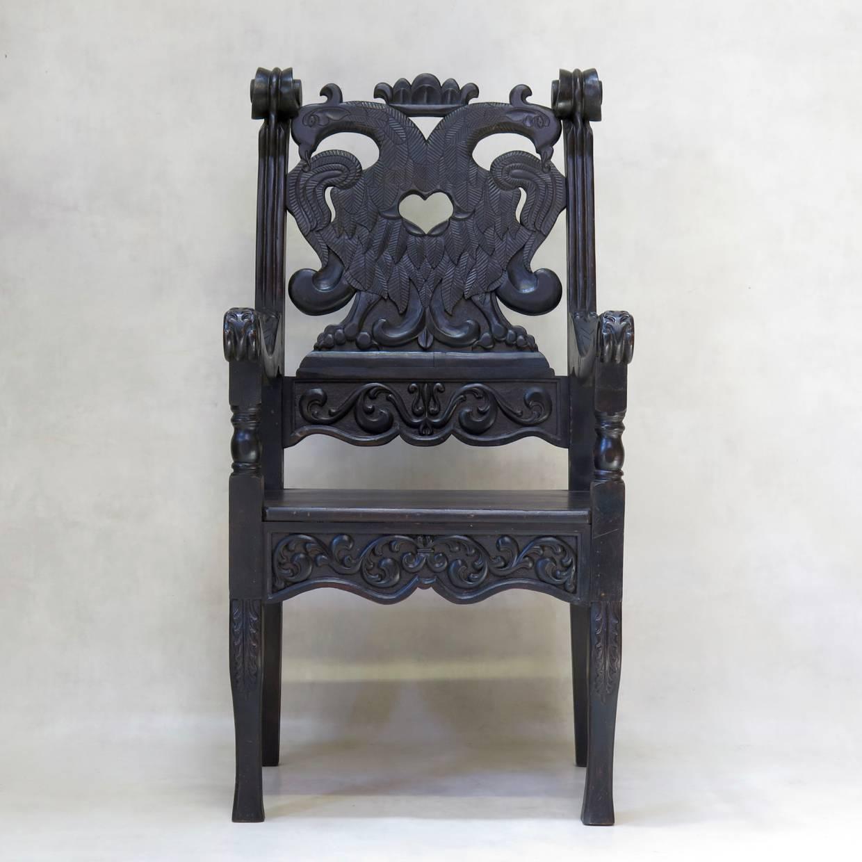 Unusual and theatrical pair of heavily carved armchairs, the backs featuring a pair of birds with finely detailed feathers.