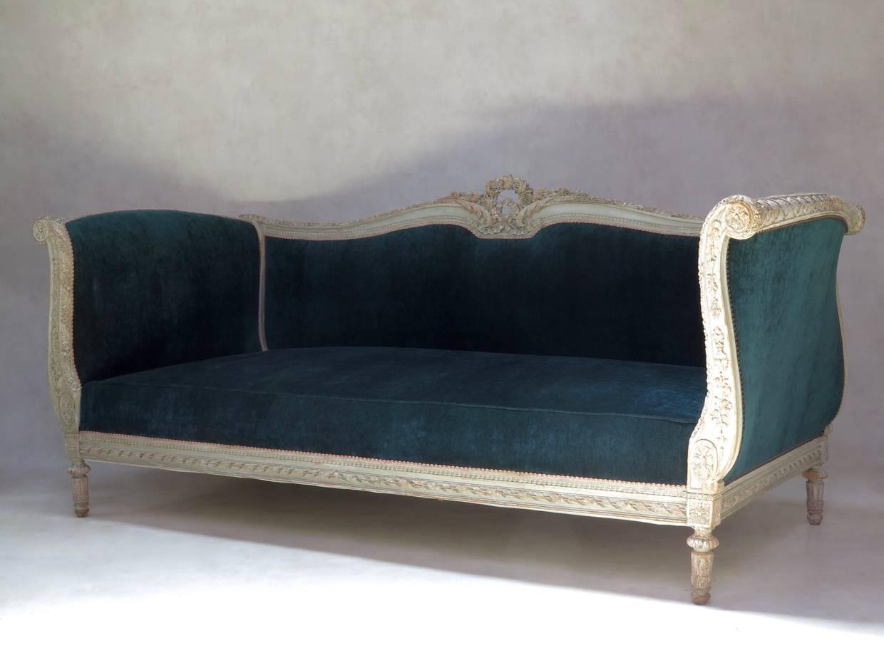 Large and deep Louis XVI style sofa. The carved wooden structure is elegantly decorated with motifs typical of the style (ribbon, flower and acanthus leaf detail on the back crest; rosettes; beading; fluted legs...) and retains its original