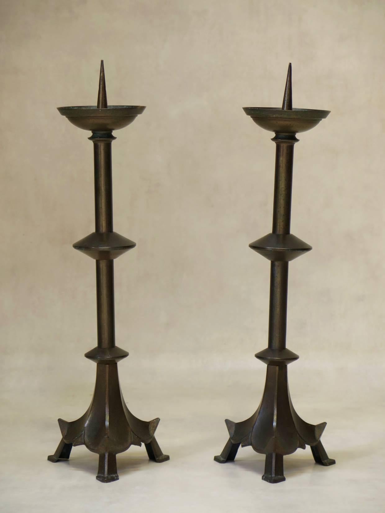 Pair of brass candlesticks of elegant design, raised on tripod bases.
