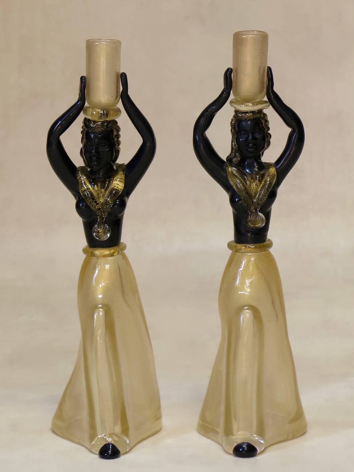 Gorgeous and rare pair of glass candle holders representing elegant dancing female figures, in black and gold-flecked amber glass. Although obviously fragile by nature, each candle stick is of thick glass and surprisingly heavy.