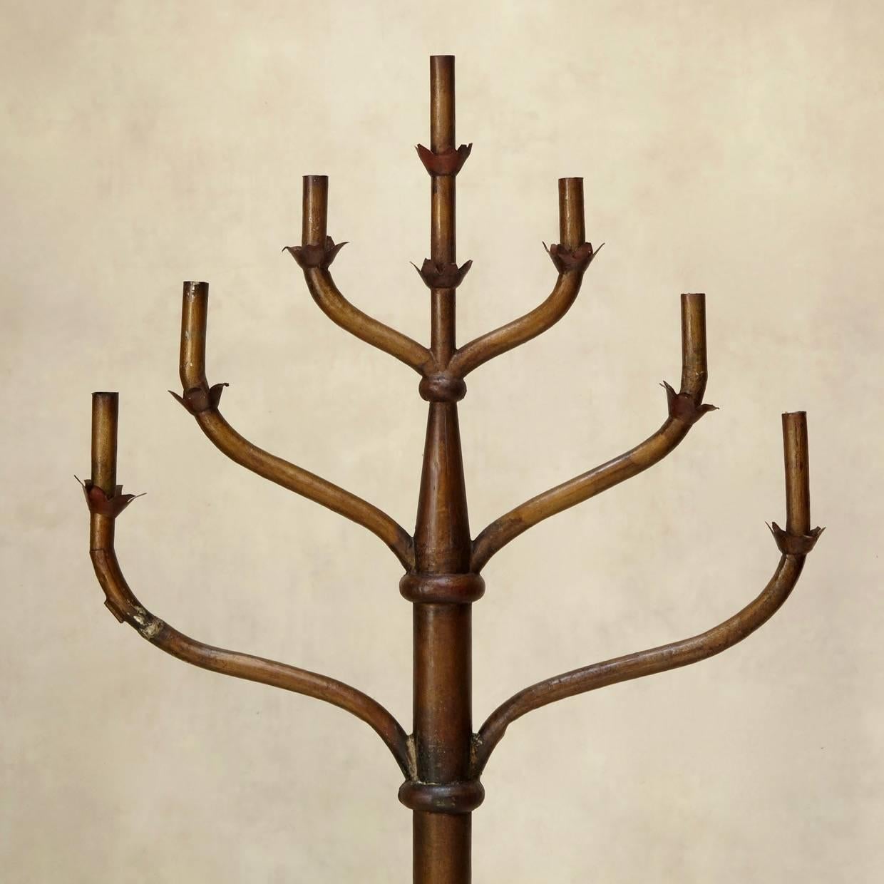 Tall, freestanding menorah-style candelabra. The lower section is carved from wood and the top is tin. Antique, burnished gold paint color.