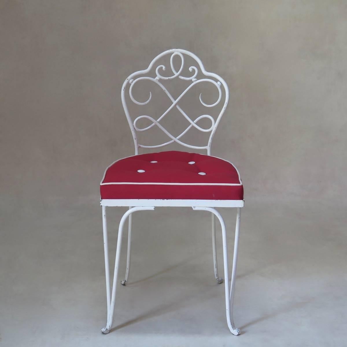 Very pretty set of four wrought iron chairs attributed to René Prou. The chairs have low backs, decorated with a delicate scrolled design. The ironwork retains its original white paint. The seats have been newly upholstered in contrasting red and