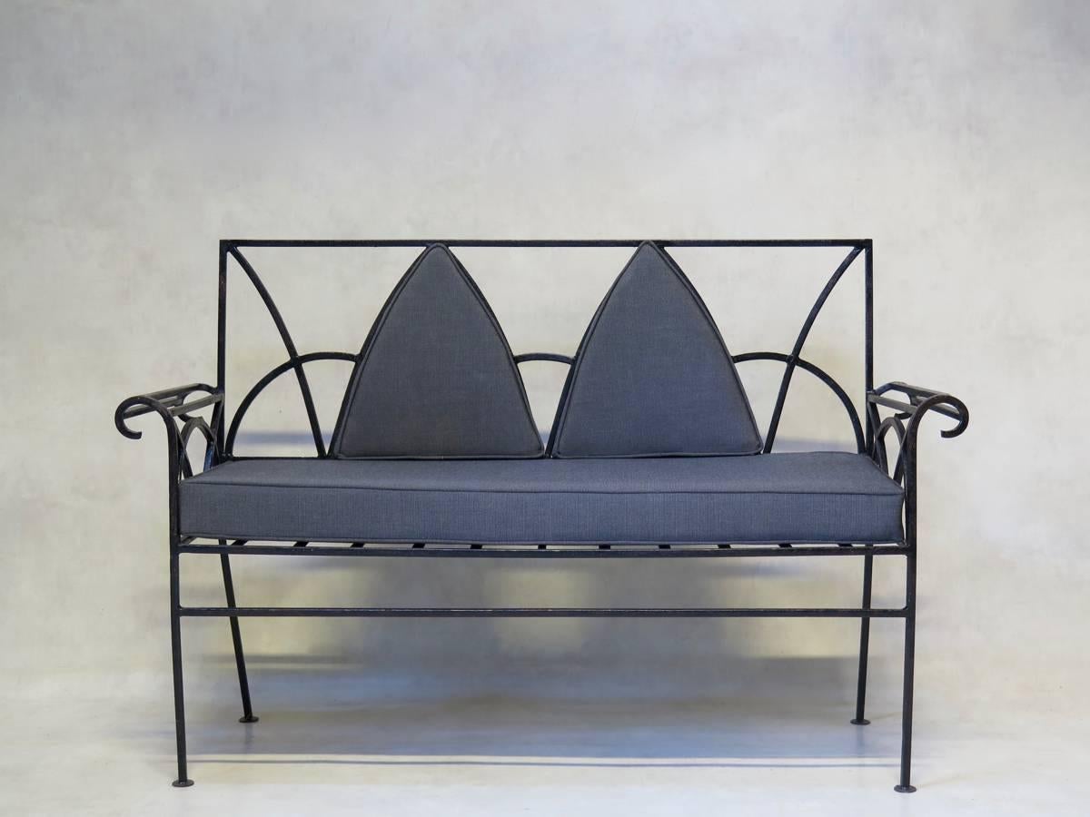 Two to three-seater sofa of elegant design, with outwardly scrolling armrests. The seat and back cushions are upholstered in dark grey outdoor fabric.