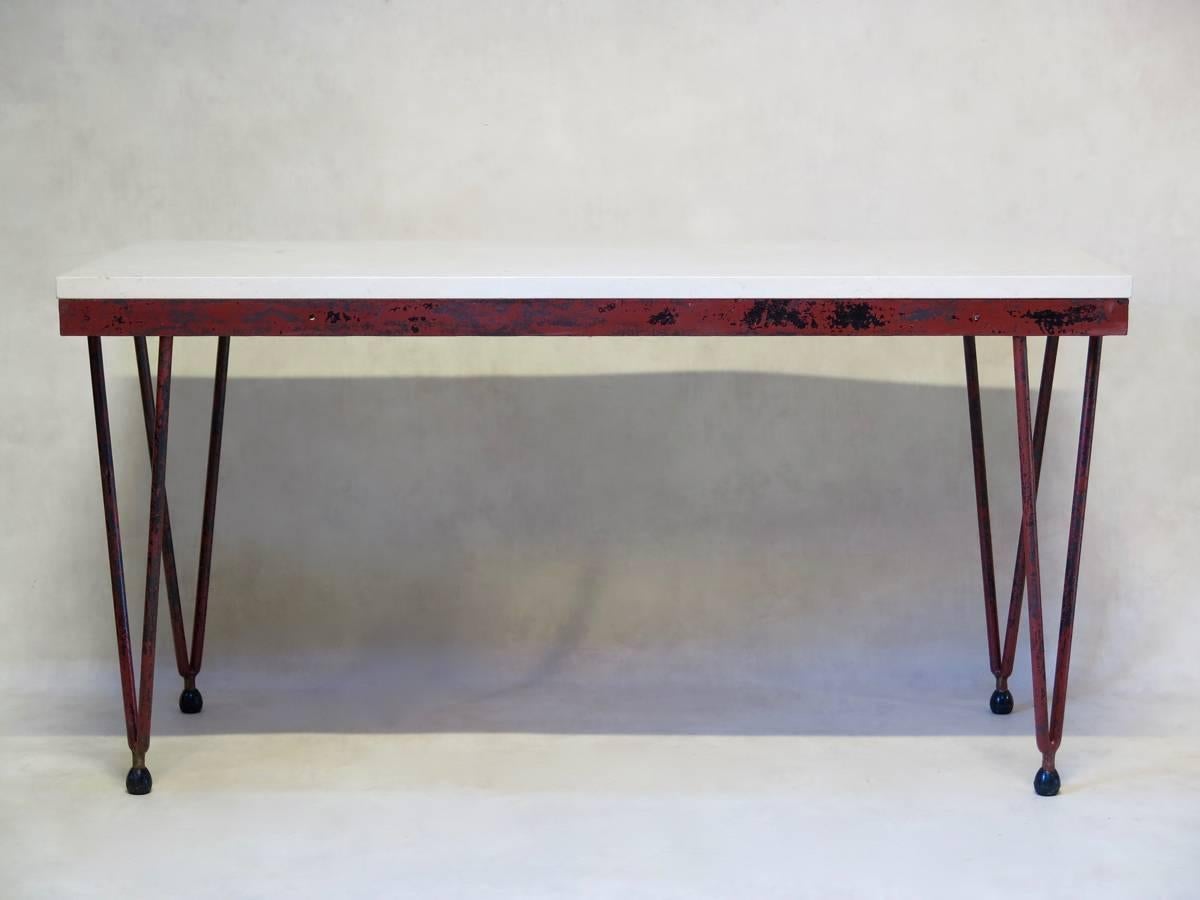 Beautiful table of simple and elegant design, with a wrought iron base painted in original dark red, and a thick slab of white stone on top, resting flush with the apron. Can be used indoors or out.
