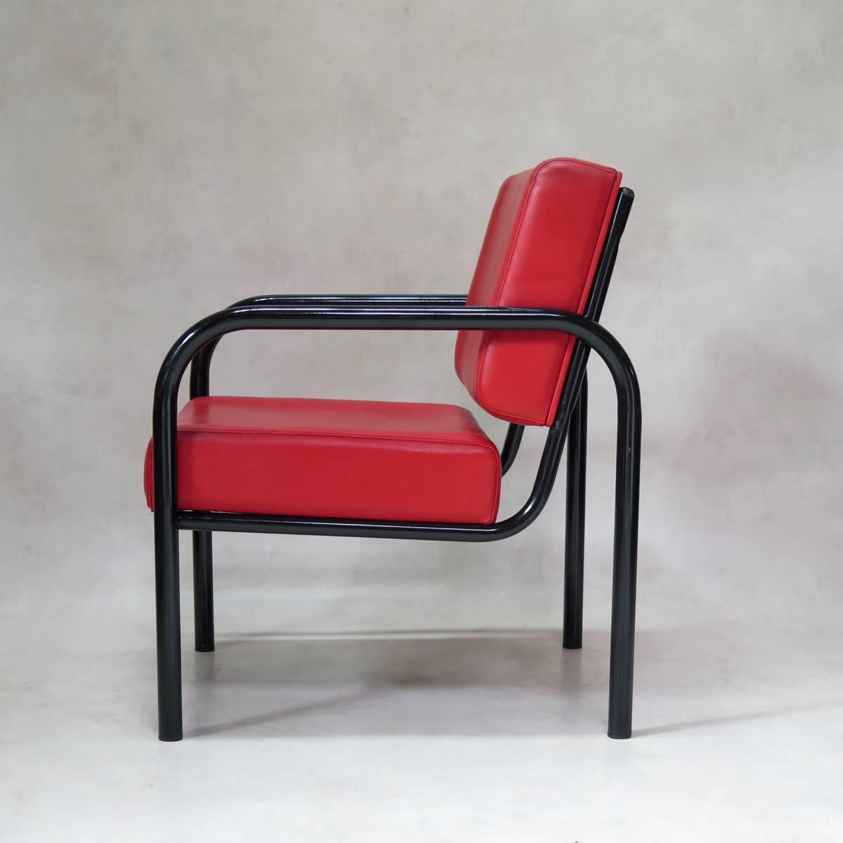 Wide and comfortable easy chair. The structure is made of tubular metal with a glossy black finish, and the seat and back are upholstered in original red leatherette. The height of the back is adjustable, as shown in the photos either resting flush