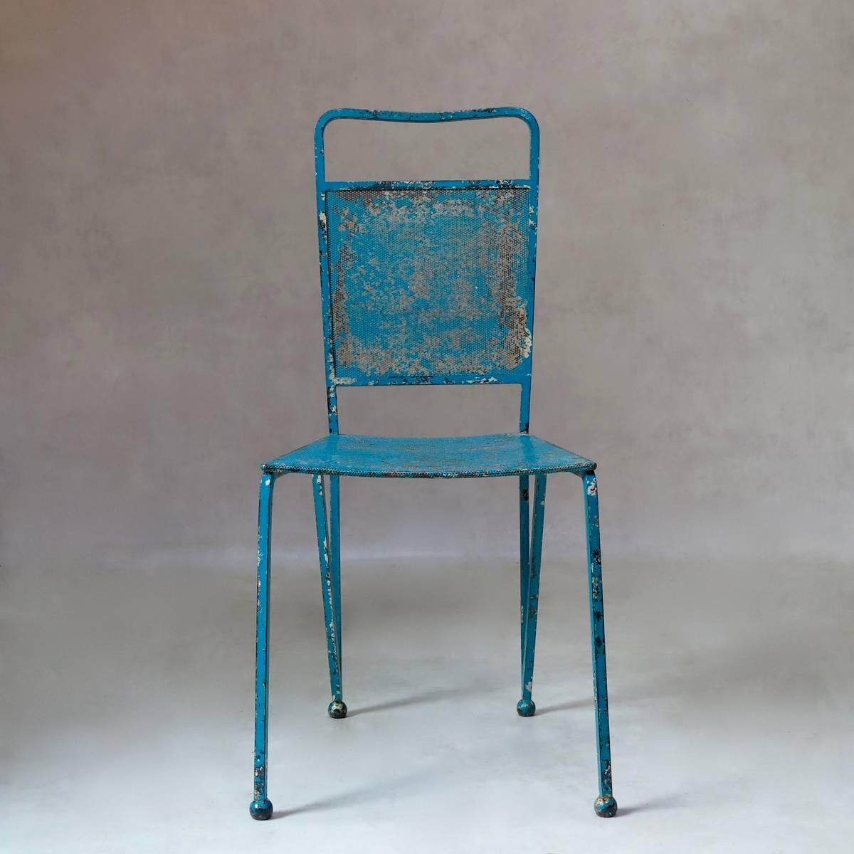 Unique set of 12 iron chairs of beautiful design. The chairs are very heavy, with sturdy, perforated sheet metal seats and backs. The structure of the chairs forms a continuous visual line from one front leg, back and around again to the opposite