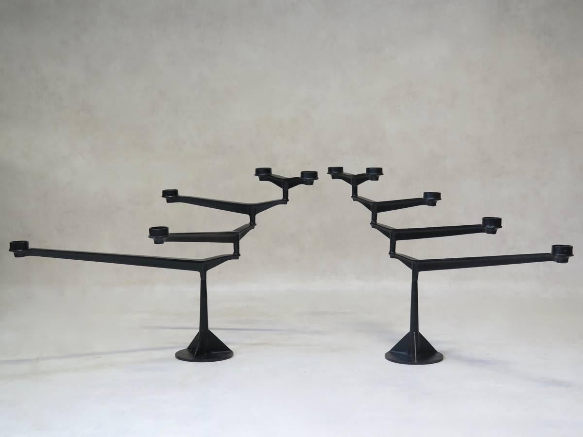 Graceful and ingenious pair of cast iron candleholders. Each candleholder has four extending arms, which can each be pivoted 360°. Very well made and striking.