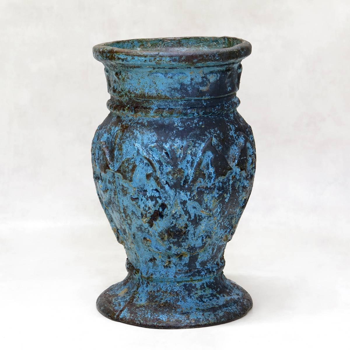 Sehr reizvoller Satz von drei gusseisernen Vasen, jede mit unterschiedlicher Originallackierung - eine blau, eine goldglänzend und eine grün-weiß. Die Farbe ist an einigen Stellen abgetragen, so dass das Eisen sichtbar wird. Hübsches