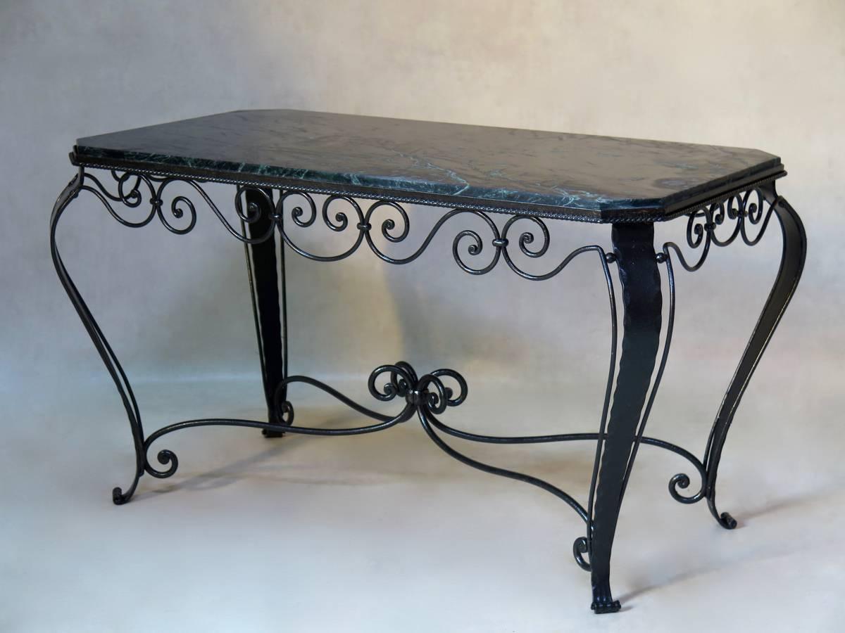 Elegant hammered and wrought iron coffee table raised on cabriole legs, with a curlicue apron. Dark green marble-top veined with black and white.