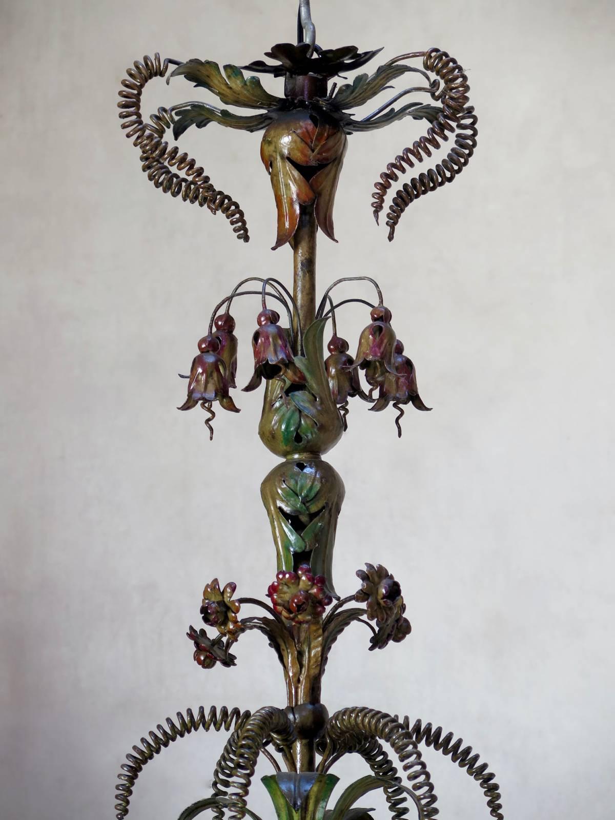 Very lovely and rare large polycromed iron chandelier, in delightful muted greens, yellows and reds. Lavishly adorned with delicately-fashioned iron flowers.