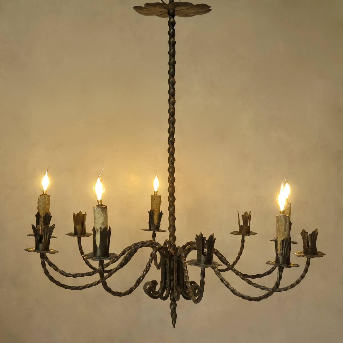 Large and elegant twisted iron ten-light chandelier. Every other arm is fitted with an antique painted wood candle and wired.