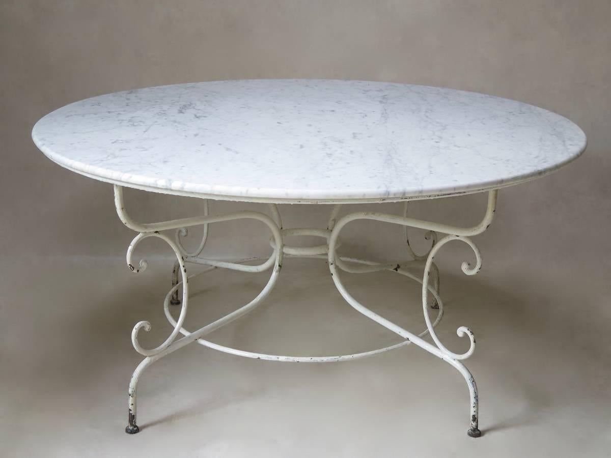 Elegant and classical round, painted iron dining table with a Carrara marble top. It is rare to find such a large example of this type of table, which can seat eight.