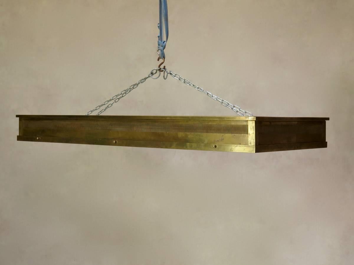 Very large and chic pair of rectangular, solid brass ceiling lights of superb quality. The fixtures are fitted with opaque glass bottoms, and can be used as either pendants or flush mounts. The lower brass part (which holds the glass) is hinged and