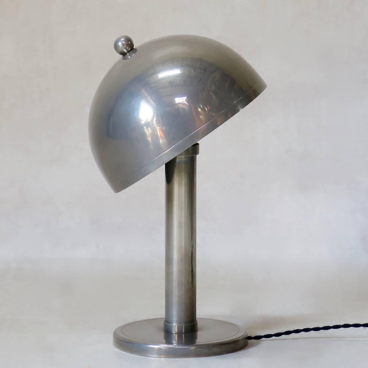 Lovely quality desk lamp of pleasant, Minimalist design, with a domed shade which can be oriented to direct the light. Very agreable nickeled finish -- softer, warmer looking than chrome, and of superior quality.