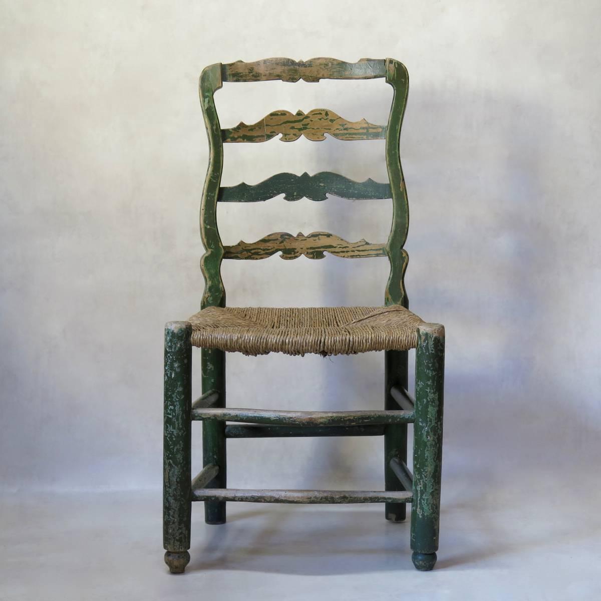 Handsome set of four antique beechwood chairs, with original green paint, and rush seats. Elegantly curved front foot rests. Wide and comfortable.