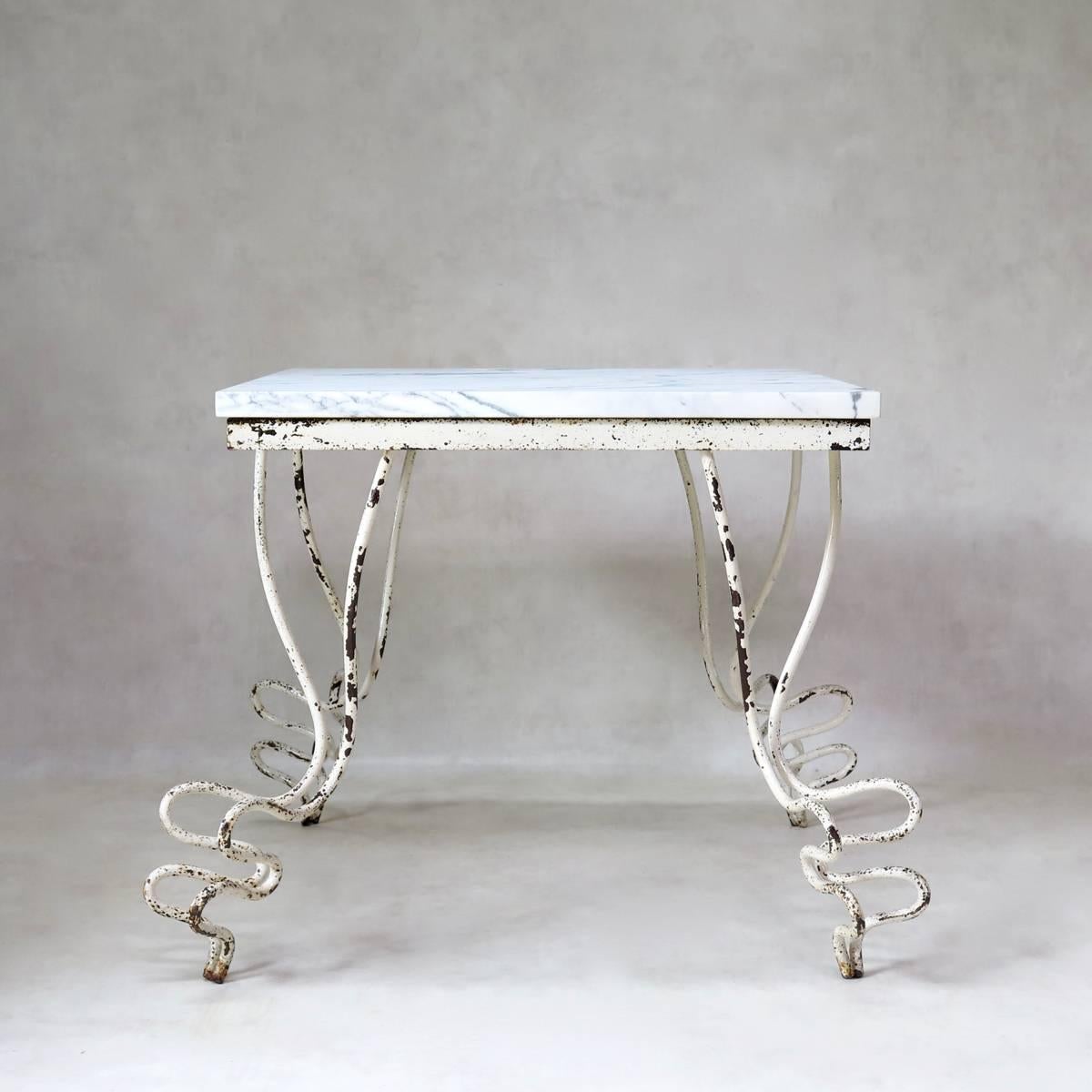 Rather wonderful and unique French Mid-Century square centre or dining table, made of wrought-iron with striking legs, and a thick Carrara marble top. Original white paint.
Suitable for use indoors or out.