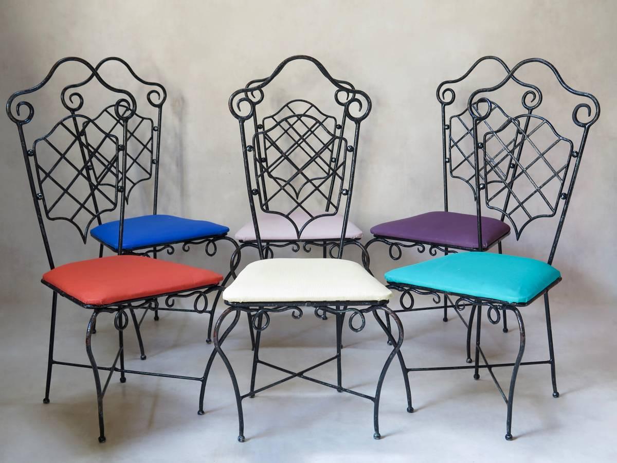 Elegant and unusual set of six hand-wrought iron chairs attributed to René Prou. The iron has a lovely, heavy feel and is painted glossy black. Traces of earlier greeny blue paint are visible beneath. Very pretty design. The chairs have shield backs