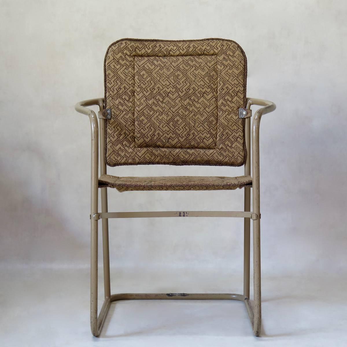 Pair of armchairs with a sleek, painted tubular metal structure and seats and backs made of geometric-patterned fabric. Original, putty-colored paint finish. The label on the base reads 