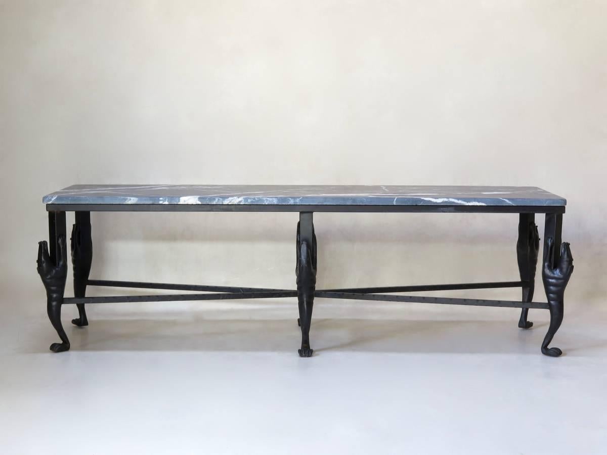Unique and fabulous long coffee table with a wrought iron base. The legs represent stylized armadillos and are joined together by a star-shaped stretcher. Dark grey marble top, veined with white.