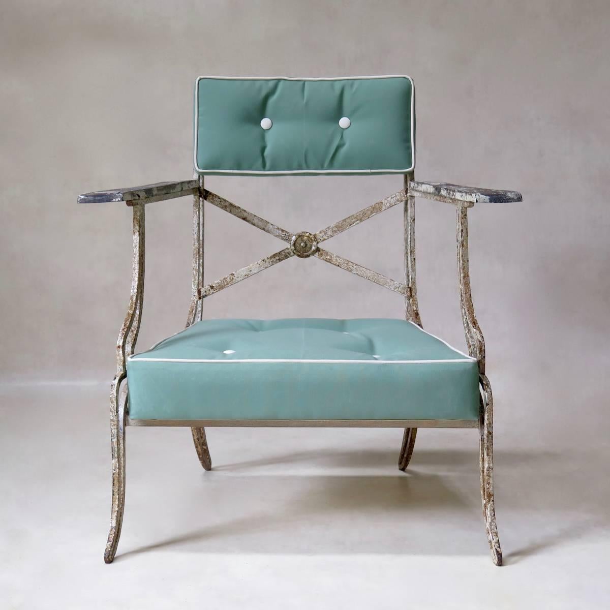 Very elegant garden set of Directoire inspiration, comprised of two armchairs and a table, of beautiful and unusual design. The wrought iron is of lovely, heavy quality, with original, patinated paint. The armchairs have wooden armrests. Newly