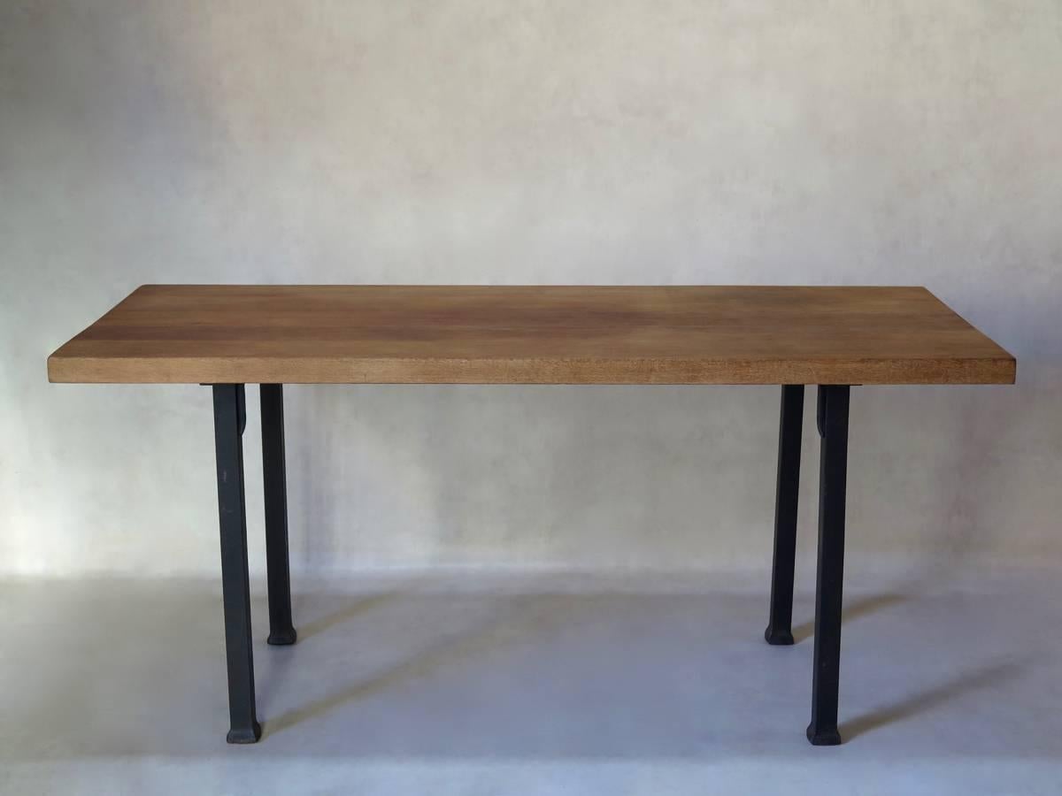 Very chic and understated table with a heavy, solid iron base which fixes to the solid oak top by means of screws. The wood has a warm, golden hue. The square legs flare out slightly at the base, subtly lending aplomb to the overall look. A refined
