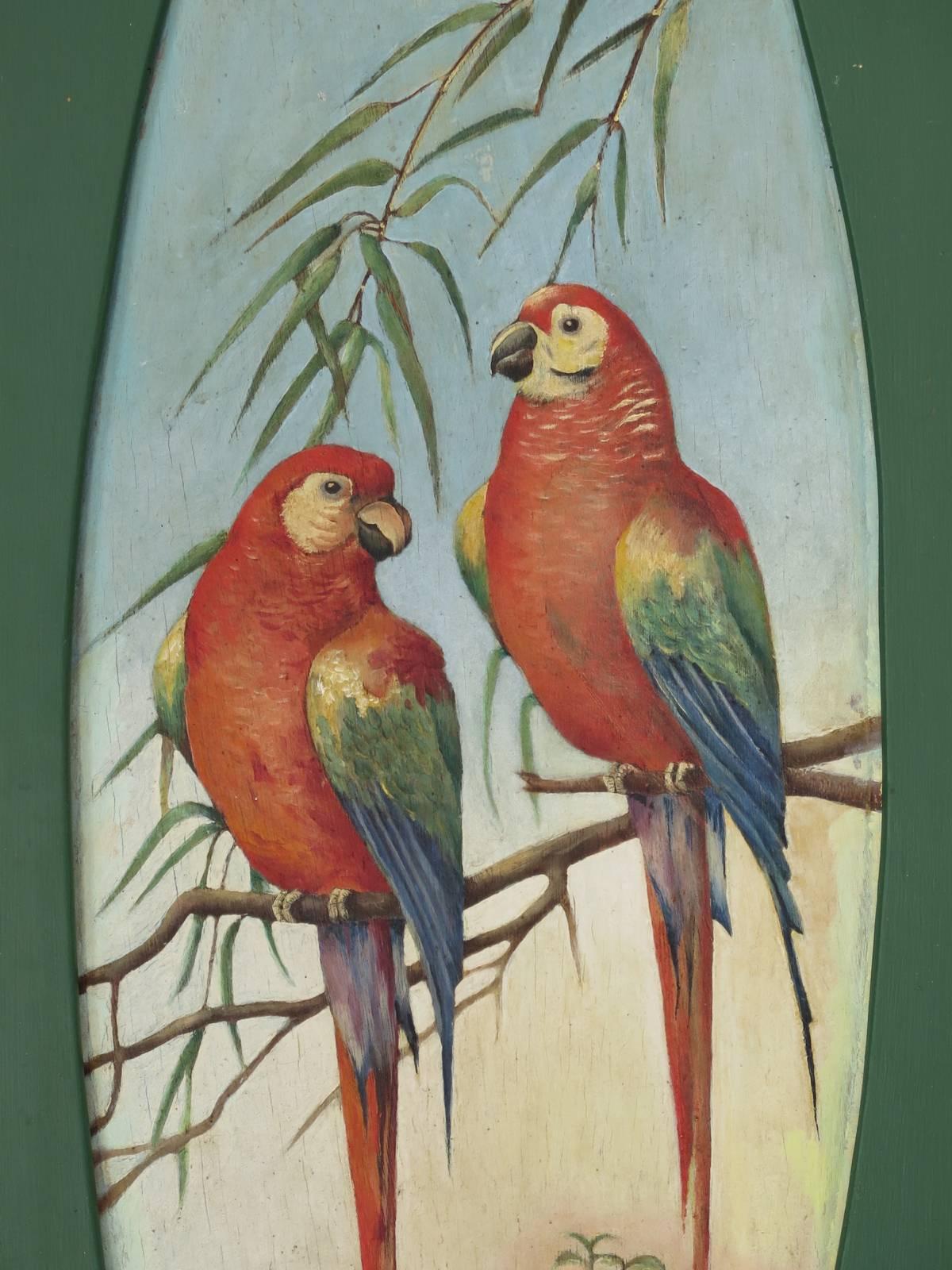 Jolie paire de peintures sur panneaux de bois, chacune représentant un couple de perroquets colorés, dans un médaillon ovale.