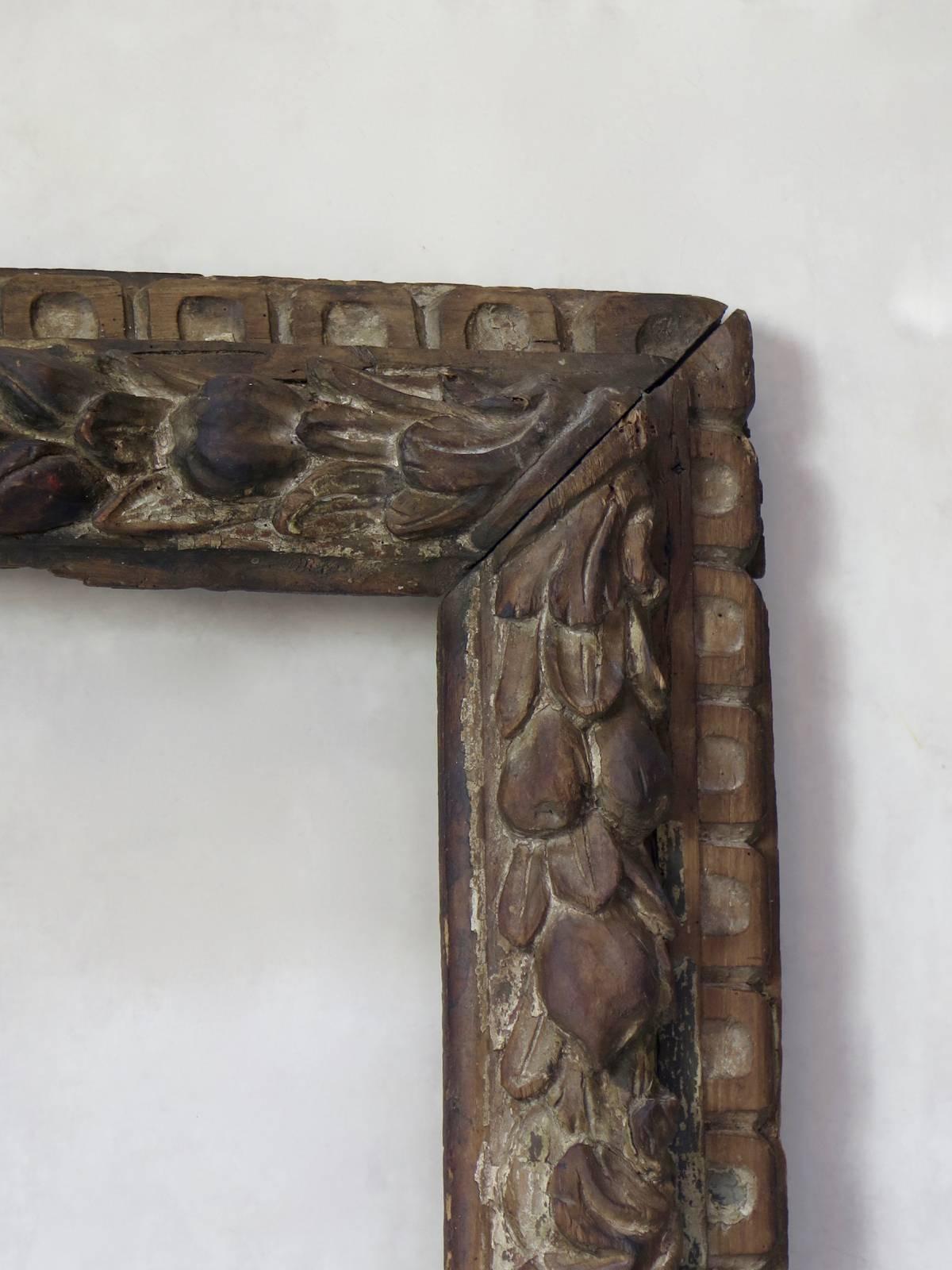 Rare and sumptuous carved wood frame, decorated with acanthus leaves, fruit and leaves (olive or laurel?). The original, polychrome pain gold and green has worn off in places.