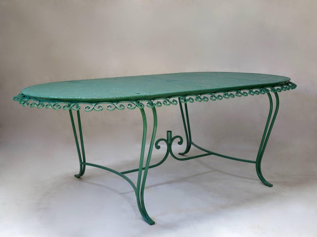 Charming Mid-Century outdoor dining set comprising a table and eight chairs, made of wrought iron, with perforated cloverleaf patterned iron table-top and chair seats.

The table has a characteristic clover-leaf patterned top, with lovely