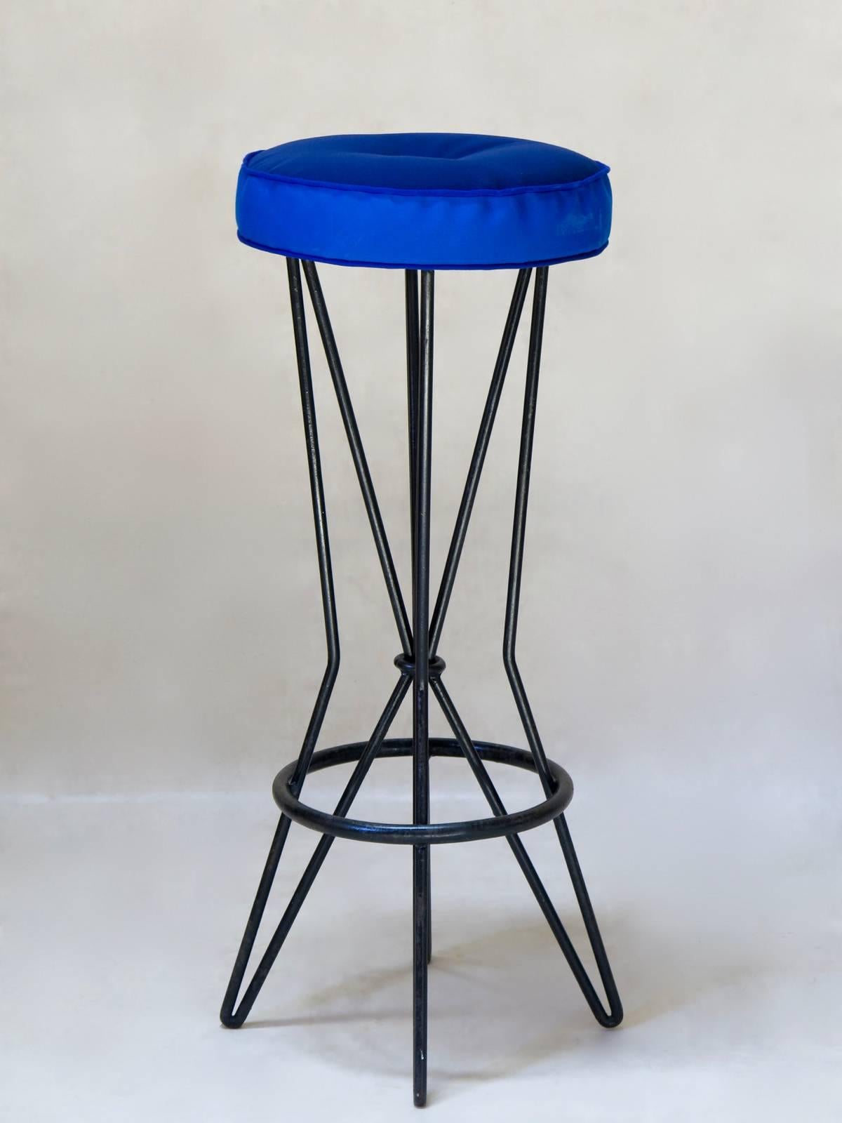 Set of six painted wrought-iron barstools with two-tone blue seats, upholstered in outdoor fabric.