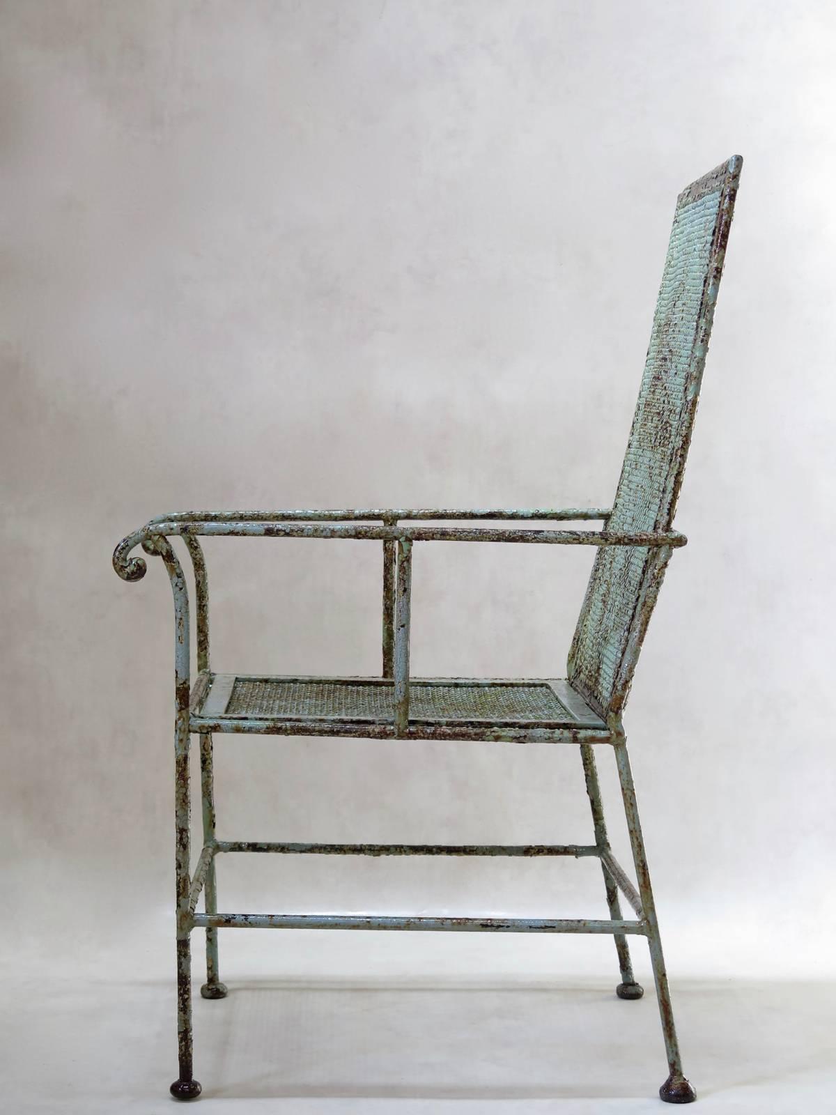Beautiful wrought iron armchair of unusual, fairly geometric design, with its original lovely green paint. The slightly inclined back is made with an intricately-knit wire mesh, and the seat with a more loosely-knit wire mesh (and more recent, circa