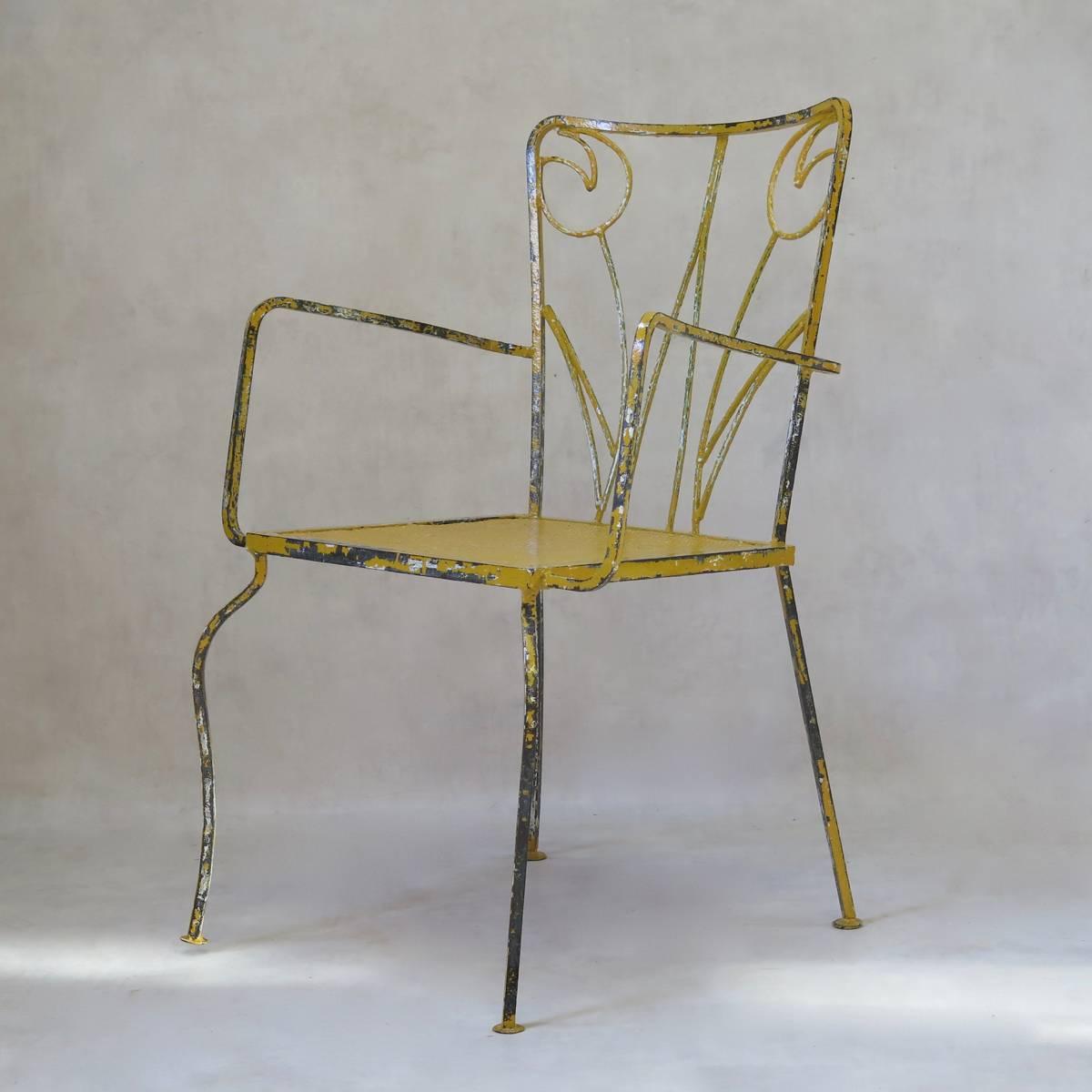 Fun and unusual set of four iron armchairs, painted yellow, with tulip motifs on the backs. The seats are of perforated sheet metal.