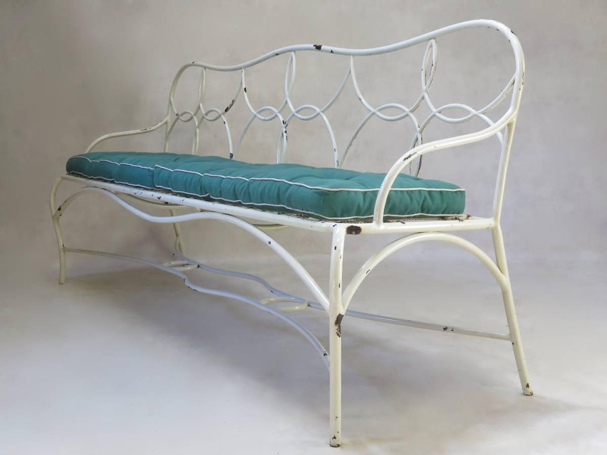 Pretty and unusual painted iron garden bench, with original green cotton canvas cushions. Sprung seat base.