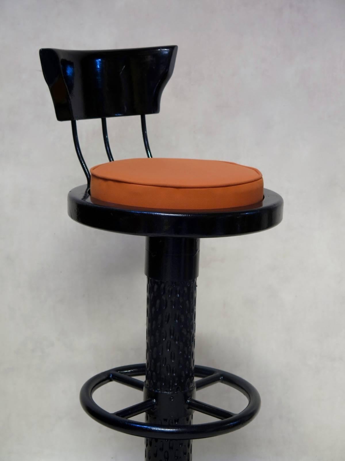 Set of eight stools with swiveling seats, and low back supports. Raised on wide, round iron bases. The stems are decorated with a gouged effect. Glossy black finish.