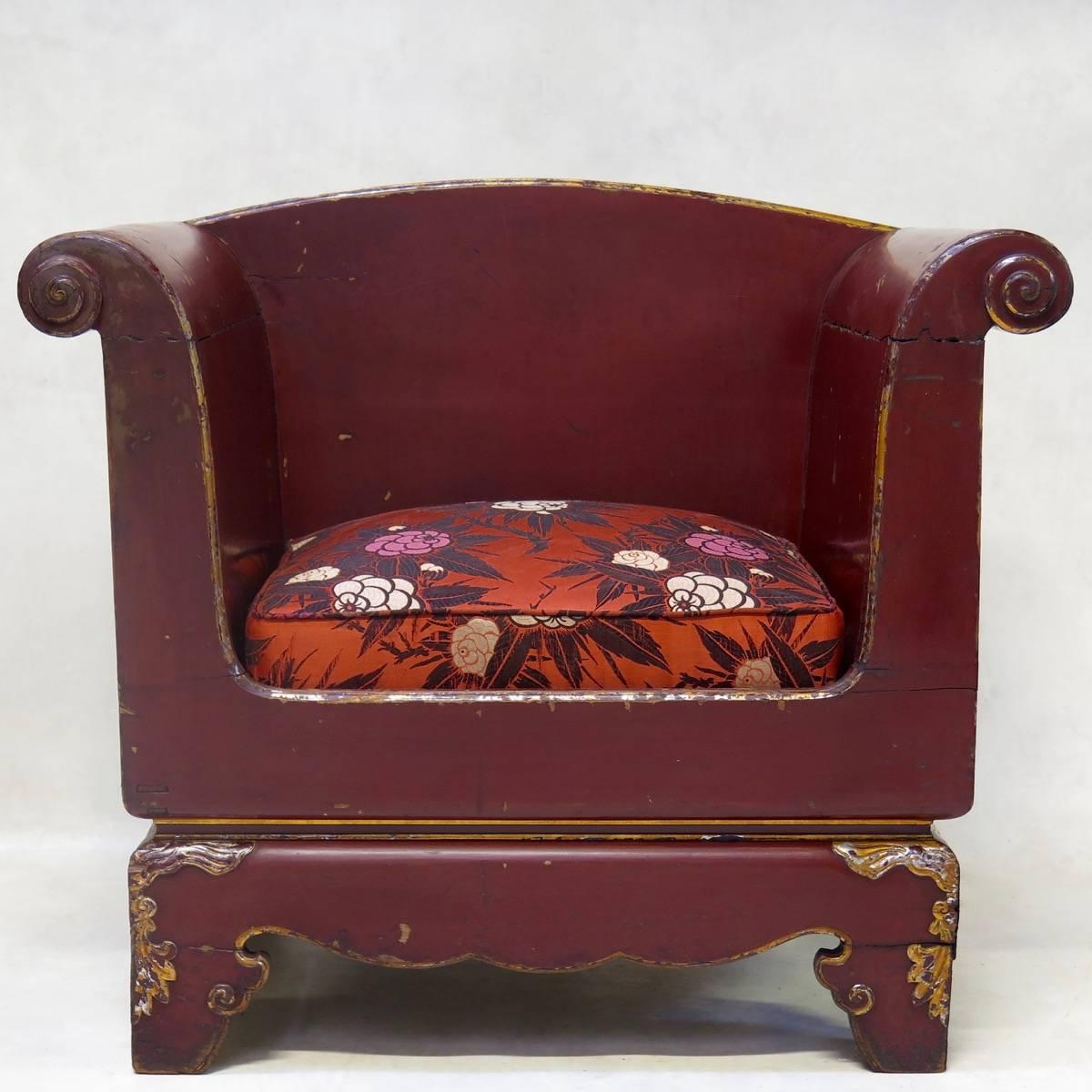 Elegant and unusual pair of wide, deep-burgundy lacquered armchairs. The scrolled armrests and the feet are highlighted with gold. The seats have been newly upholstered in vintage silk Art Deco fabric.