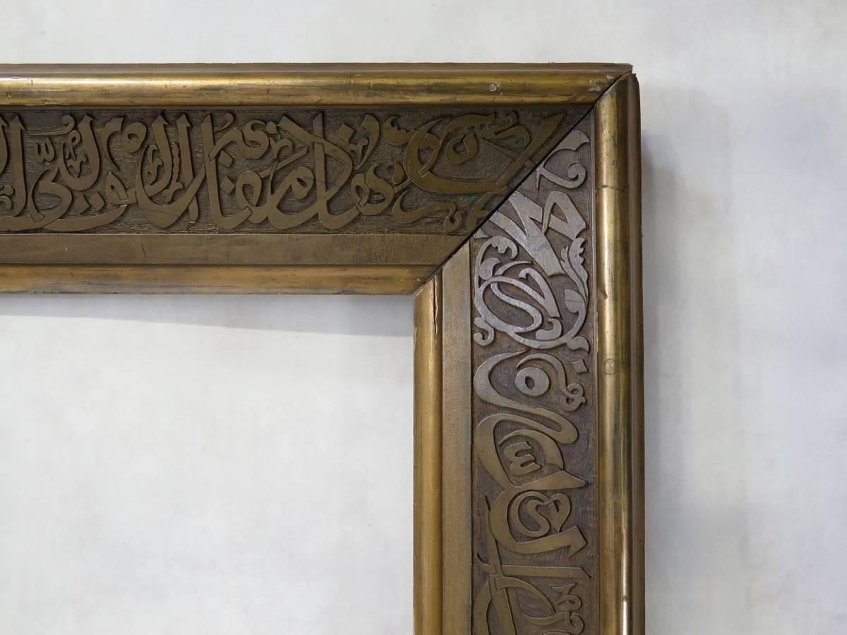 Rare et élégant cadre en bois peint à l'or de très grandes proportions, sculpté de calligraphies arabes sur tout le pourtour.