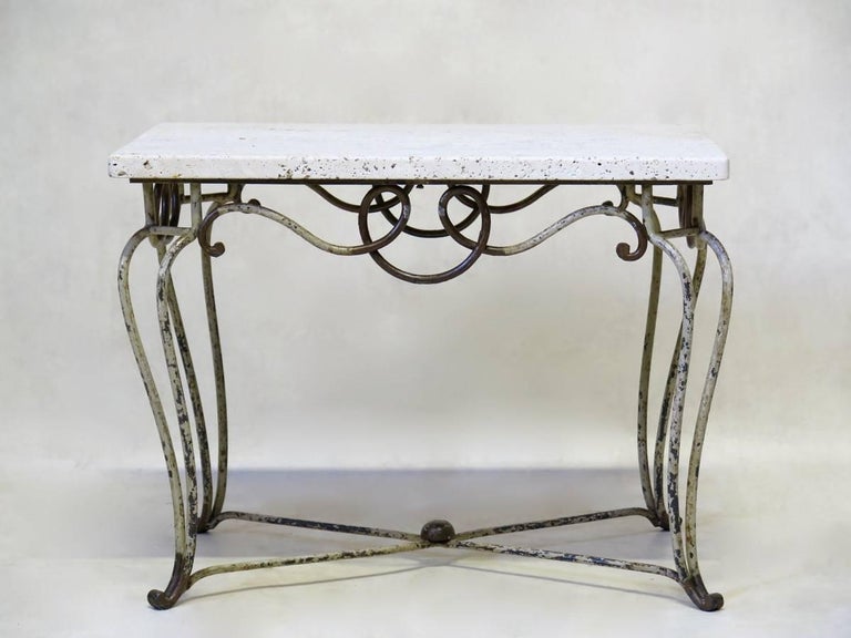 Elegant and petite Art Deco coffee or side table, with a wrought iron base presenting curlicue motifs around the apron, and cabriole legs. The iron has traces of the original gold and cream-coloured paint. Travertine top.