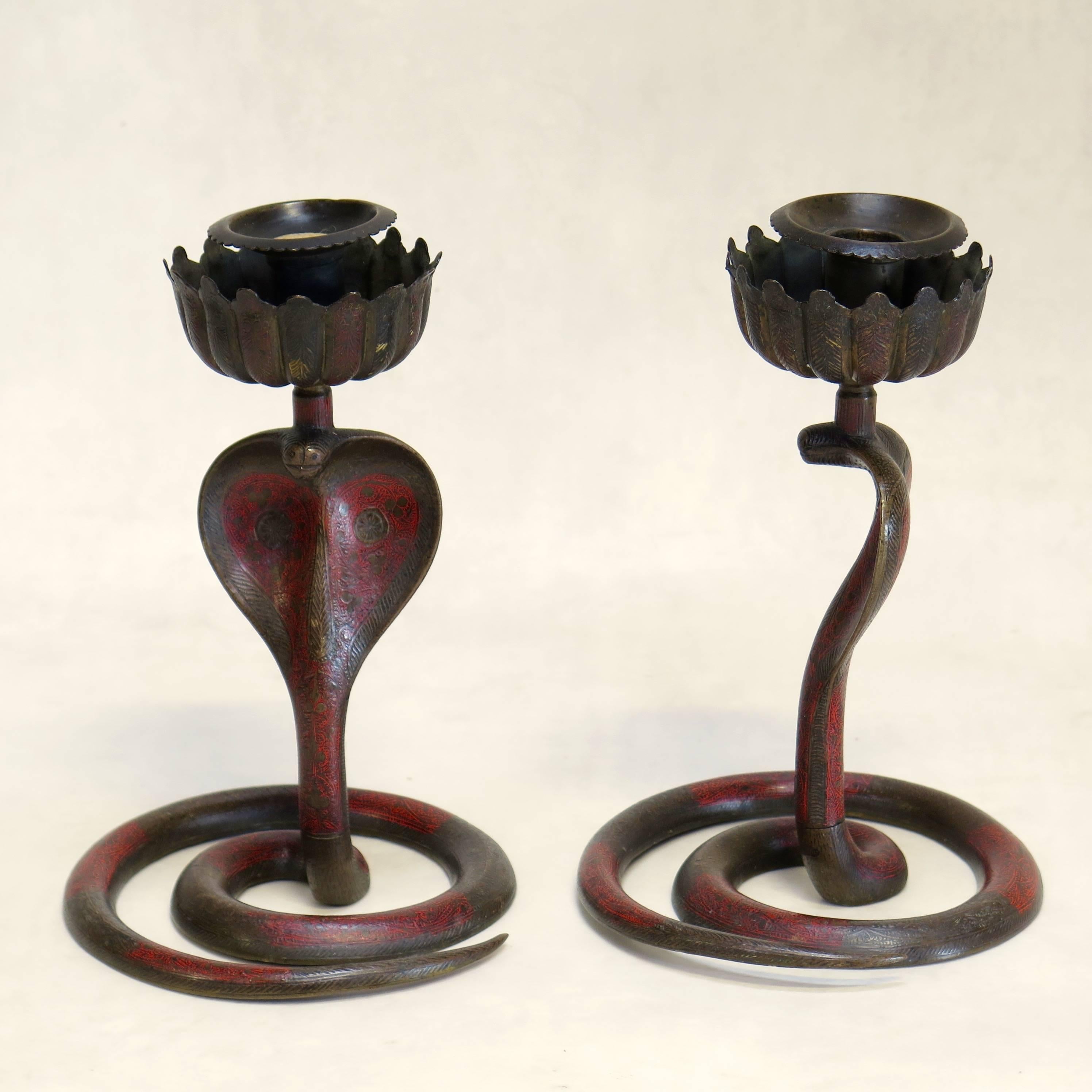Exotic pair of brass candlesticks with intricate etched pattern and red enamel finish.
