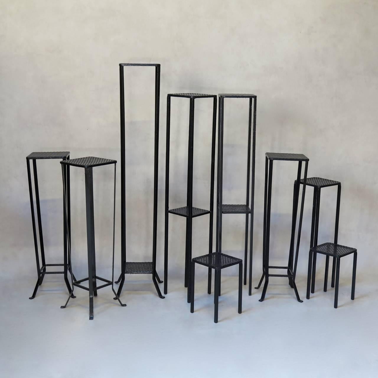 Set of nine plant stands of various shapes and sizes, painted black, with cloverleaf-patterned sheet metal tops. From a florists.

Dimensions provided below are for the tallest. For comparison, the smallest pair measures (in