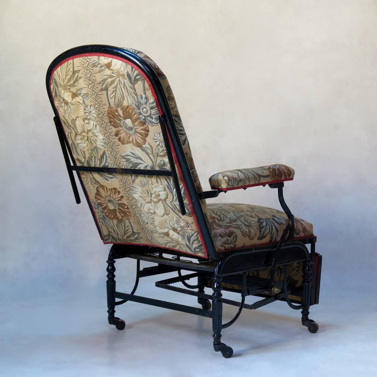 Very fine iron Campaign-style armchair with adjustable positions, from upright to horizontal. Raised on casters. Newly upholstered with vintage fabric. 

Dimensions provided below are for the chair fully folded (i.e. at its smallest).