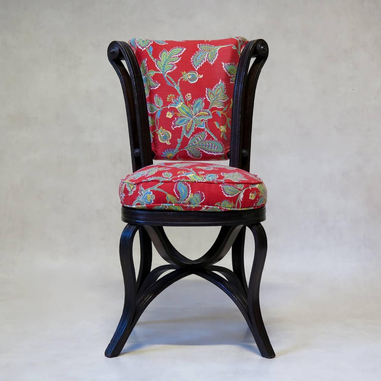 Rare and charming pair of antique bentwood chairs, possibly by Thonet. 
The design of the chair is ingenious and creates a lovely, fluid movement: the chair is made so that one piece of bentwood runs up from the front foot, crosses over, up and