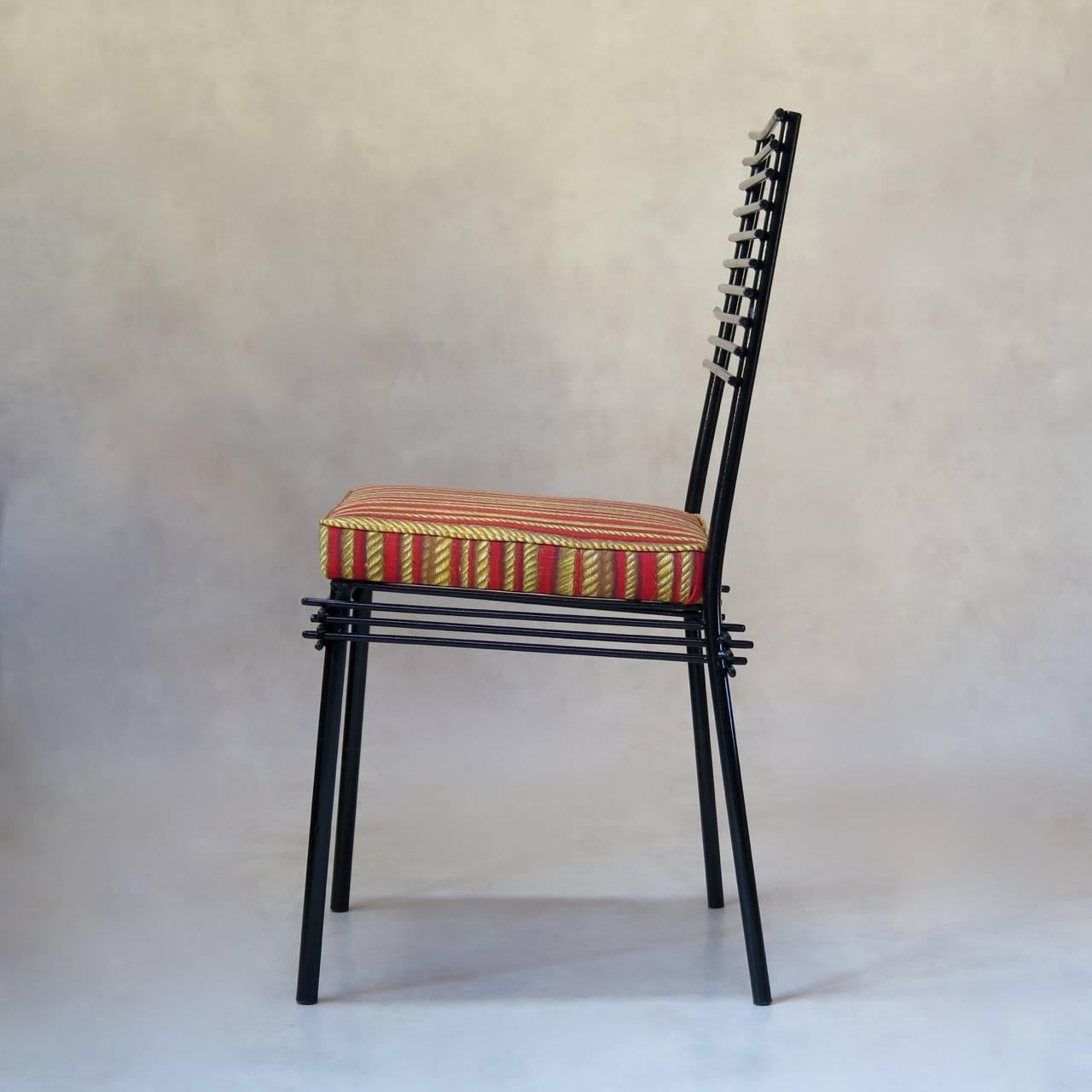 Chic and understated set of four dining chairs with a simple iron structure, painted black. The backs feature a simple design of thin horizontal rods. This motif is repeated around the aprons.

The seats have been newly re-upholstered with new,