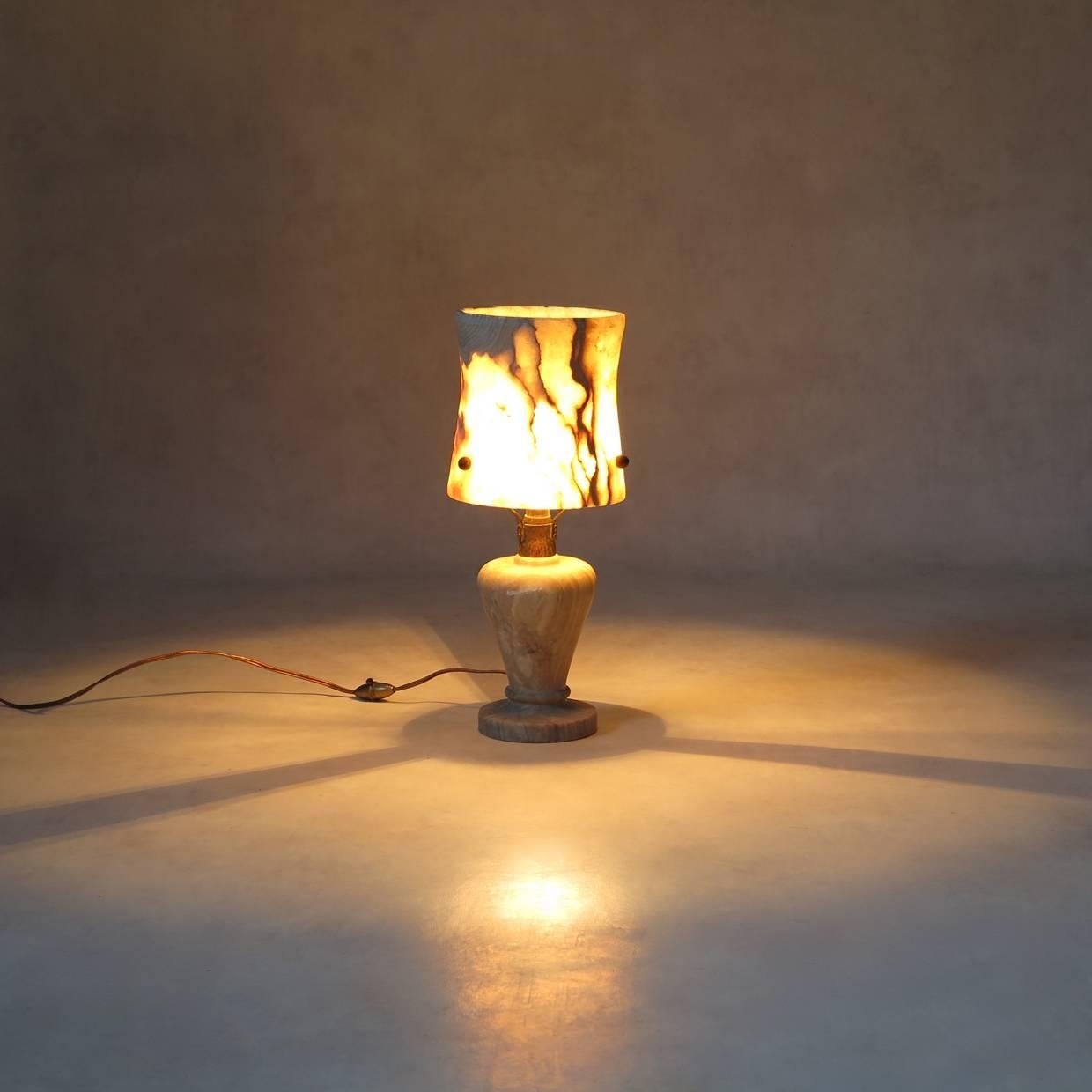 Unusual and very pretty table lamp carved out of solid mica. The lamp shade is almost a centimeter thick. When lit, all the veins in the stone come to life, and the lamp gives off a very lovely, soft light. The shade is fixed to the base by three