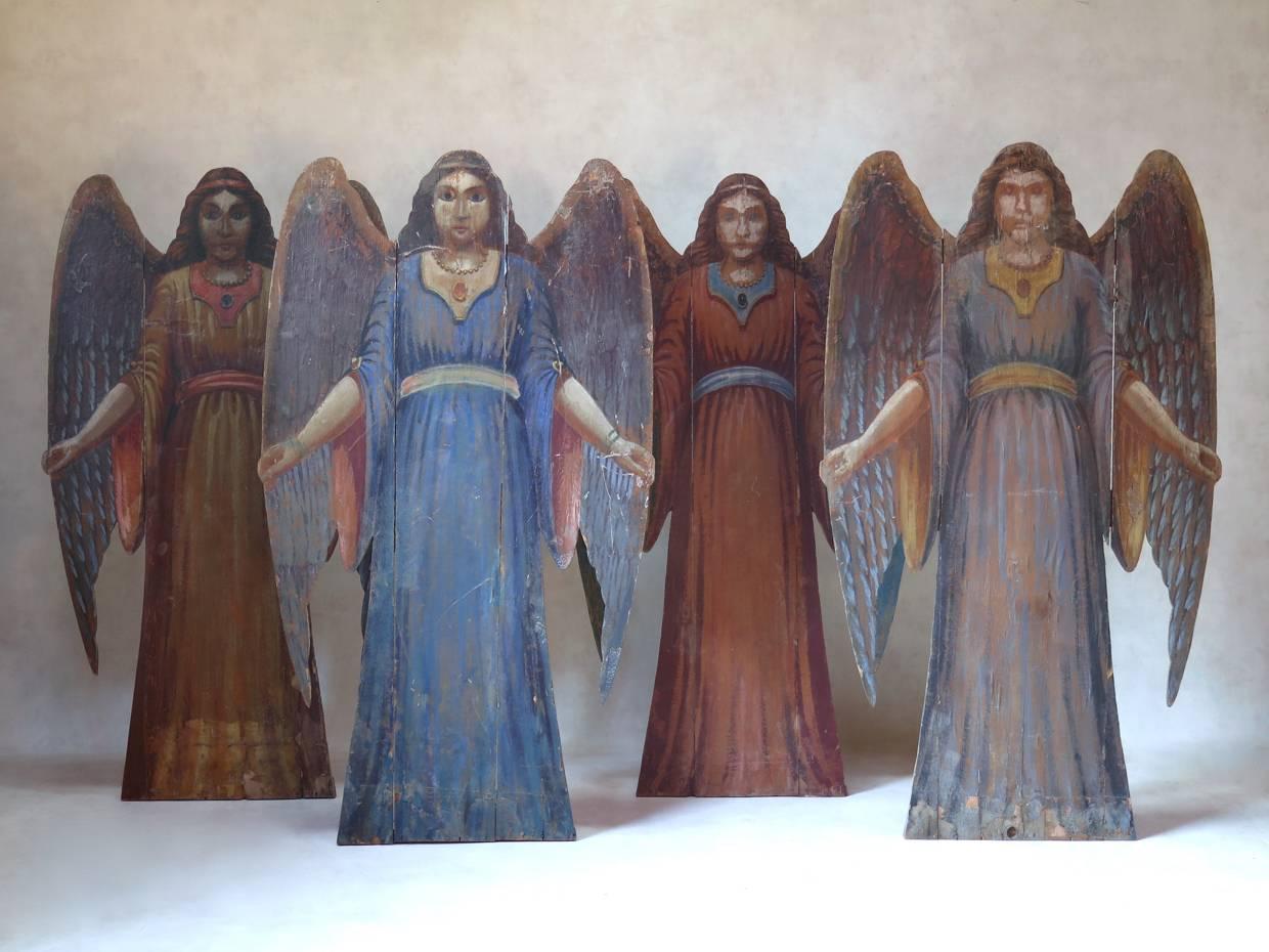 Delightful set of four cut-out angels made for a theatre decor. Hand-painted on paper, pasted onto wood backing. Lovely, soft colors. Each one is different.