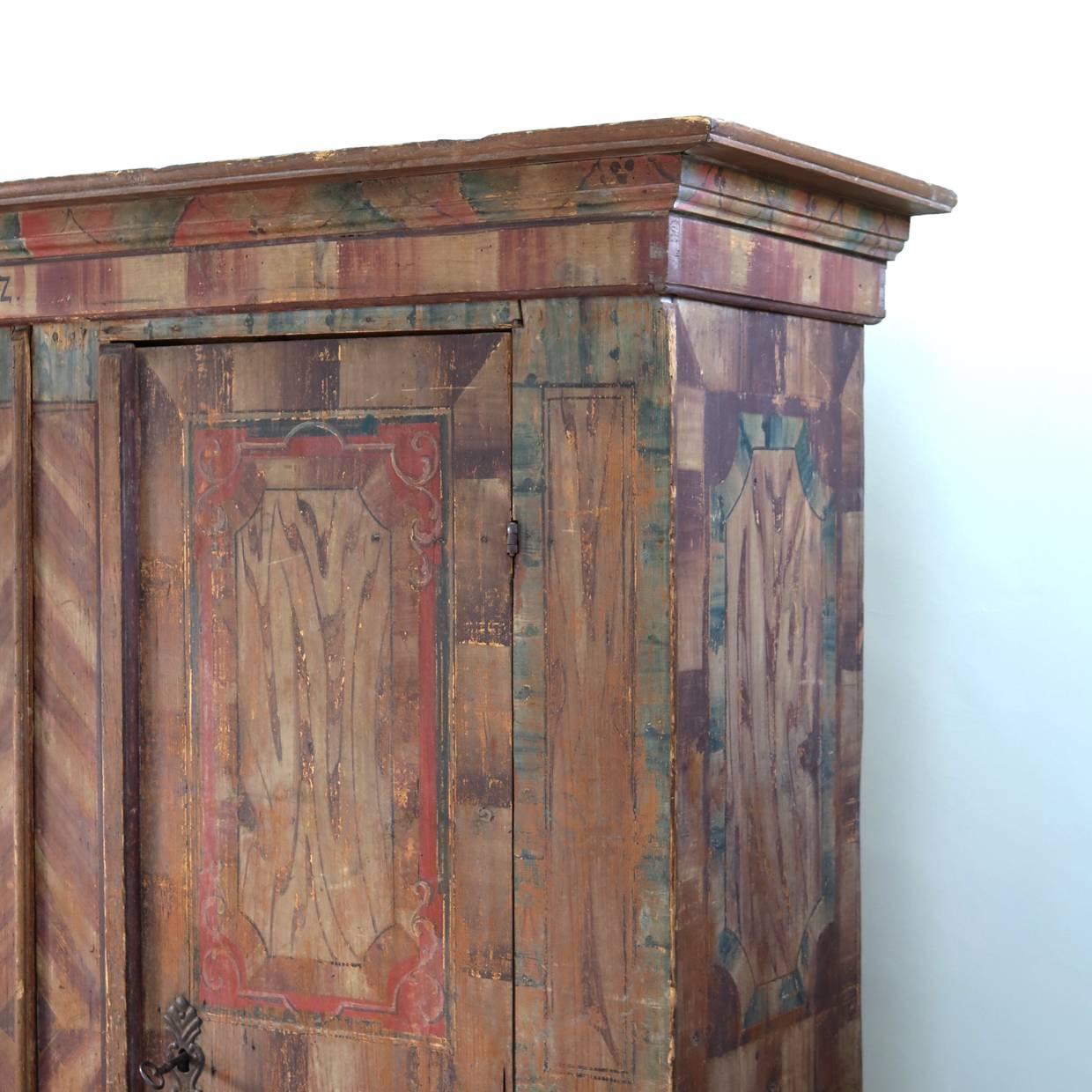 Charming, rustic two-door pine armoire with polychrome oche-toned decor, dated 1752. 