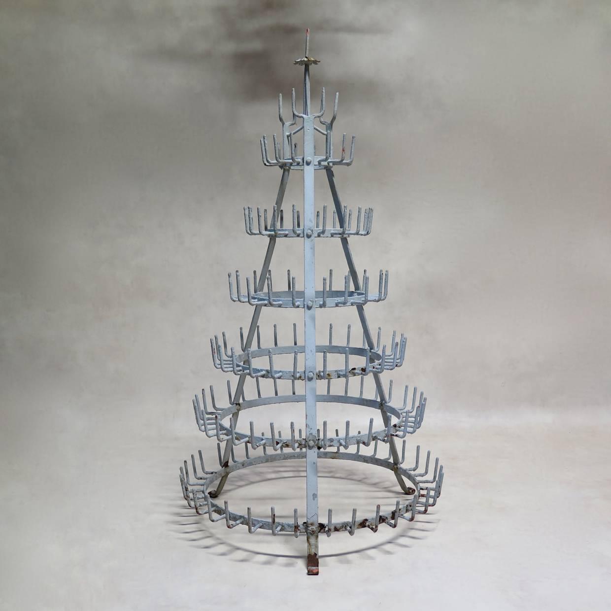 Sturdy and decorative conical wrought iron bottle dryer, with original light grey paint. Orange primer visible beneath.