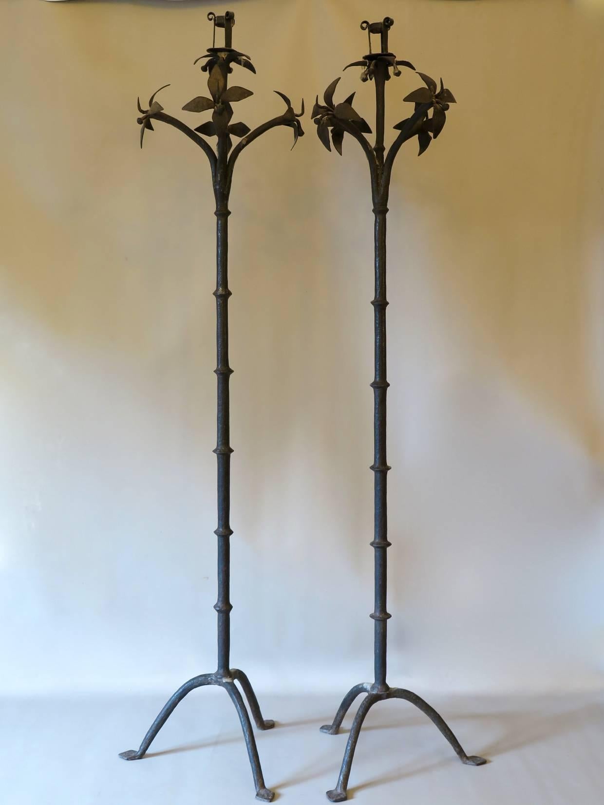 Elegant and rare pair of heavy wrought iron candleholders with a crown of flowers, raised on a tripod base.
Probably from Italy.