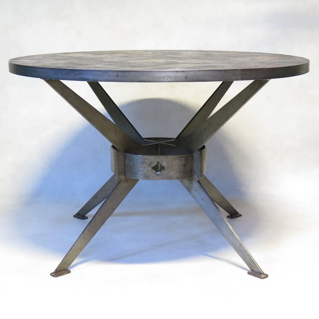 Table ronde unique en son genre avec une base et un entourage en acier brossé. Le sommet est composé d'une mosaïque de carreaux d'ardoise gris foncé et de couleur rouille.