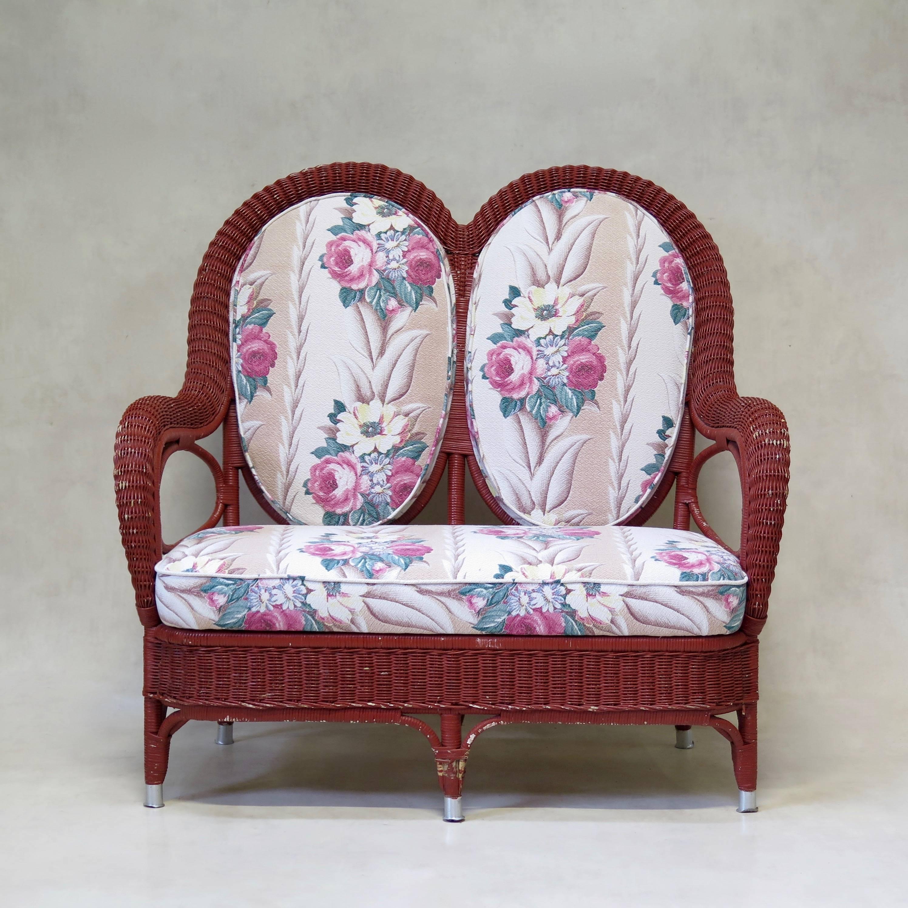 Comfortable and charming living-room or veranda seating set composed of a two-seat sofa and a pair of armchairs. Painted in the original deep red-colored paint. Newly upholstered in vintage fabric. The feet are clad in aluminium-type metal.