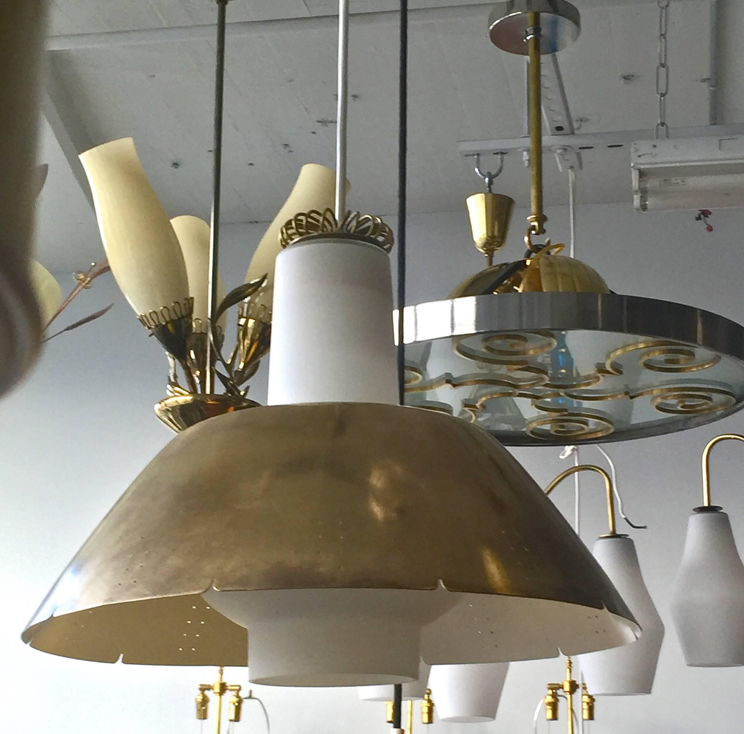 A pendants designed by Paavo Tynell for Idman, Finland, circa 1950.
Perforated brass, opal glass and brass wire crown.
Existing electrical wiring. Rewiring available upon request.
