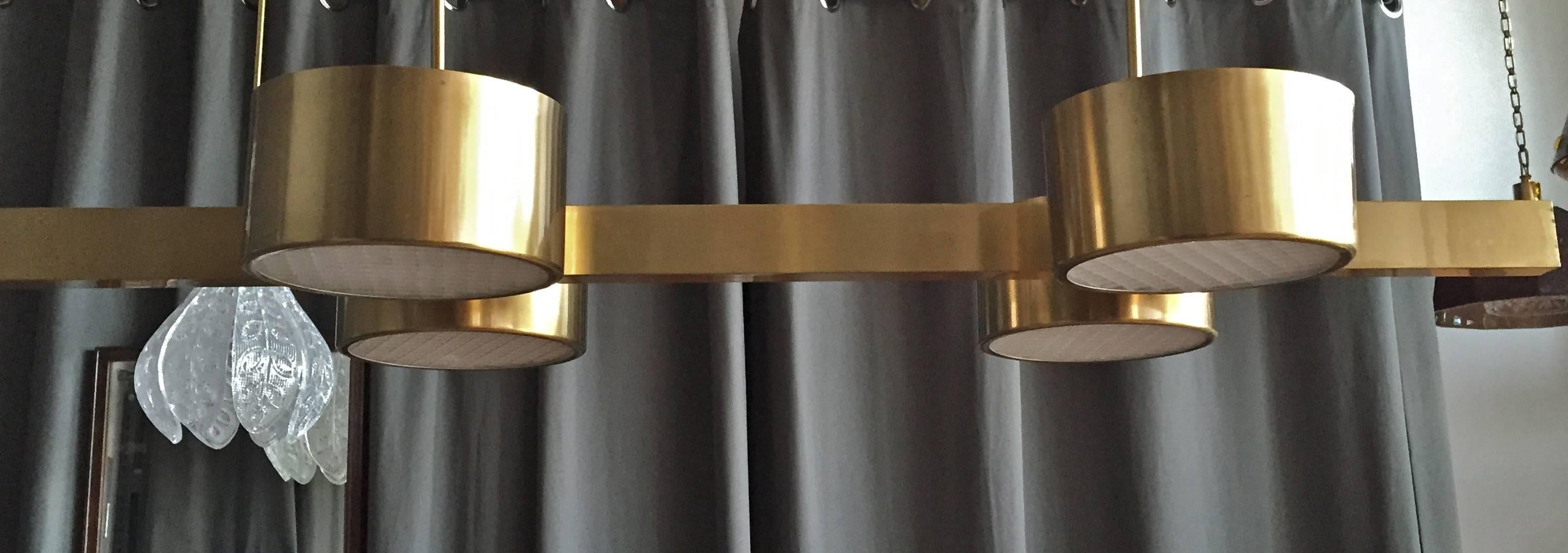 A chandelier designed by Hans-Agne Jakobsson, Sweden, 1970s.
Manufacturer label attached.
Four-light brass structure on two rod's, the shades with acrylic diffusers.
Polished and lacquered brass.
Measures: Height 34”, length 43”, depth 19